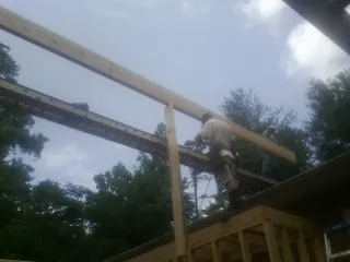 Carpenter setting a ridge beam over a new addition frame — Ice Dam Removal by Roofing Brothers in Newcastle
