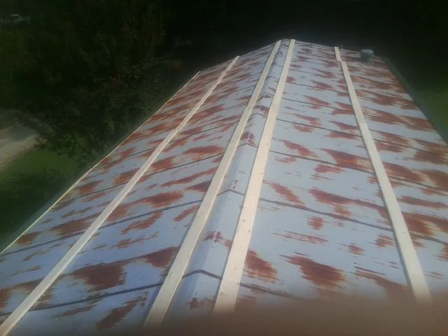 Rusted metal roof panels with new wood purlins before replacement — Storm Damage Roof Repair in Newcastle by Roofing Brothers